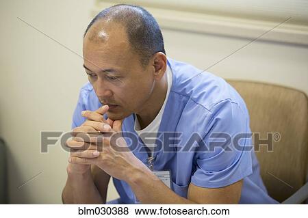 Stock Photo - Pacific Islander nurse sitting in hospital lobby. Fotosearch
