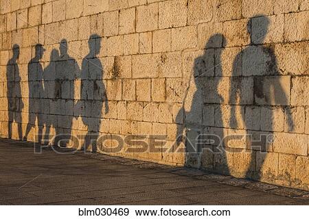 Stock Photo - Shadow of people on stone wall. Fotosearch