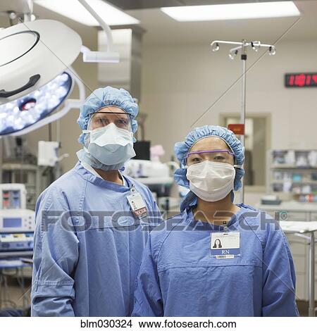Picture - Surgeons standing in operating room. Fotosearch