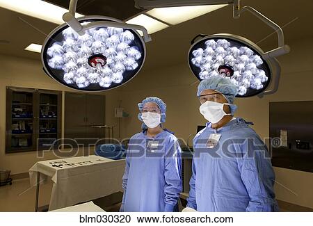Surgeons standing in operating room View Large Photo Image Stock Image - Surgeons standing in operating room. Fotosearch