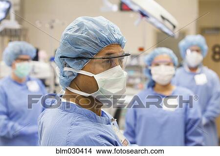 Picture - Surgeons wearing masks in operating room. Fotosearch