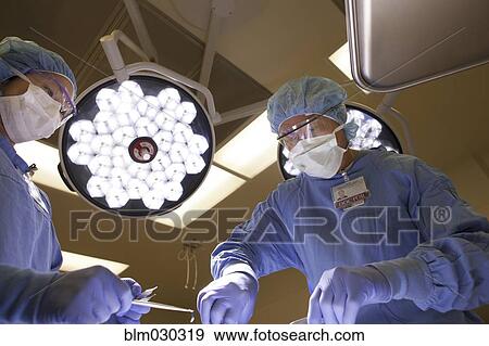 Stock Photo - Surgeons working in operating room. Fotosearch