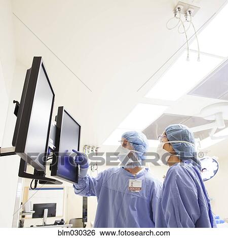 Surgeons working in operating room View Large Photo Image Stock Photograph - Surgeons working in operating room. Fotosearch