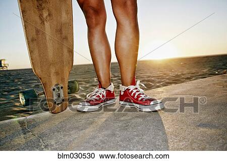 Woman holding longboards on beach View Large Photo Image Stock Image - Woman holding longboards on beach. Fotosearch