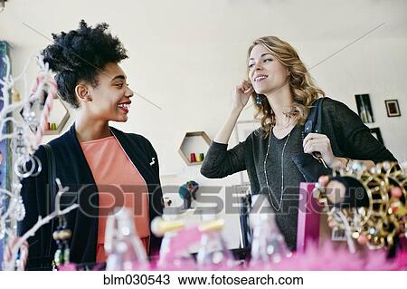 Stock Image - Women shopping together in store. Fotosearch