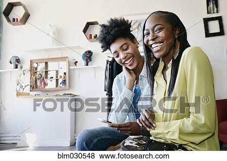 Women using cell phone in store View Large Photo Image Stock Photo - Women using cell phone in store. Fotosearch