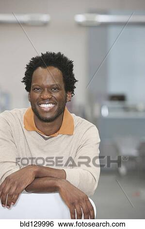 Stock Photograph - African American businessman smiling in office. Fotosearch