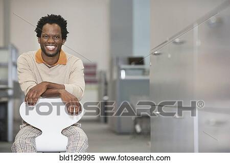 Stock Photography - African American businessman smiling in office. Fotosearch