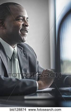 Picture - African American businessman working at desk. Fotosearch