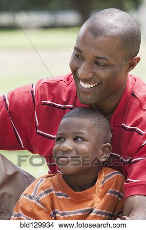 African American father and son sitting in park View Large Photo Image Picture - African American father and son sitting in park. Fotosearch