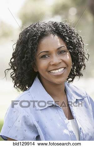 Picture - African American woman smiling outdoors. Fotosearch