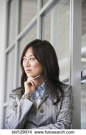 Asian businesswoman smiling in office View Large Photo Image Picture - Asian businesswoman smiling in office. Fotosearch