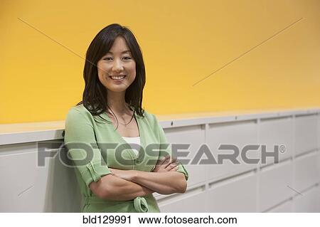 Asian businesswoman smiling in office View Large Photo Image Stock Image - Asian businesswoman smiling in office. Fotosearch