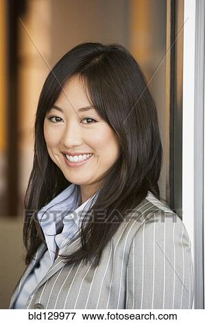 Stock Photo - Asian businesswoman standing in doorway. Fotosearch
