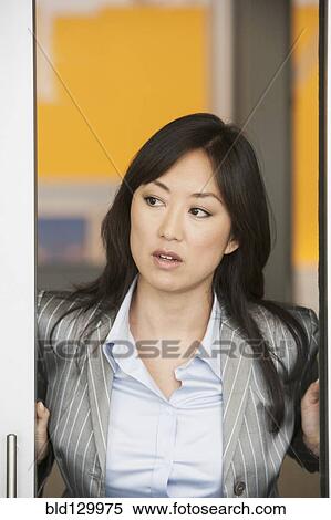 Stock Photography - Asian businesswoman standing in doorway. Fotosearch