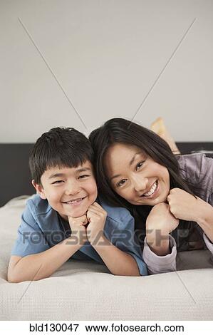 Asian mother and son laying on bed View Large Photo Image Stock Photo - Asian mother and son laying on bed. Fotosearch
