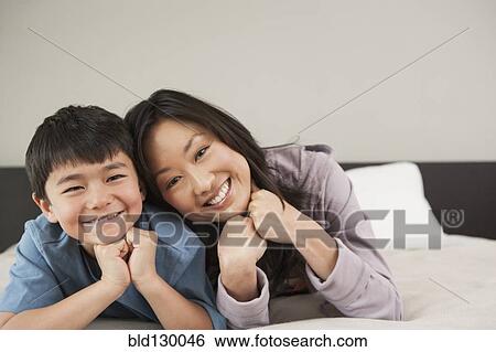 Asian mother and son laying on bed View Large Photo Image Stock Photograph - Asian mother and son laying on bed. Fotosearch