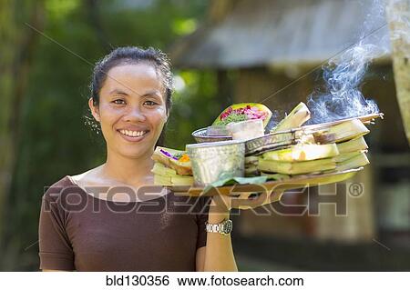 Balinese woman carrying tray of food View Large Photo Image Stock Photograph - Balinese woman carrying tray of food. Fotosearch