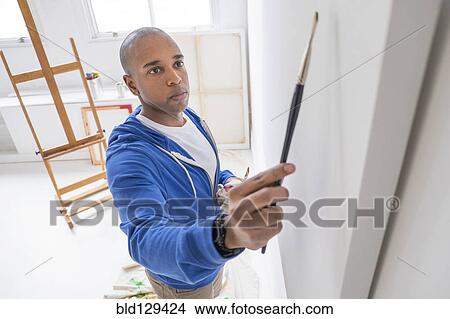 Picture - Black artist painting in studio. Fotosearch