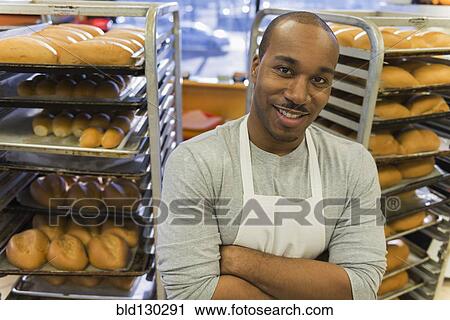 Stock Image - Black baker working in commercial kitchen. Fotosearch