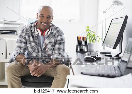 Stock Photo - Black businessman working in office. Fotosearch