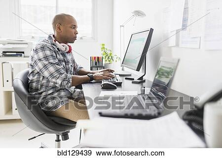 Stock Photo - Black businessman working in office. Fotosearch