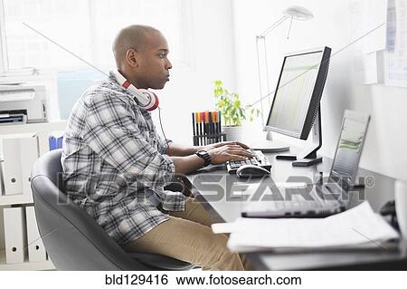 Stock Photograph - Black businessman working in office. Fotosearch