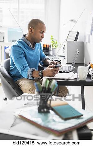 Stock Photography - Black businessman working in office. Fotosearch