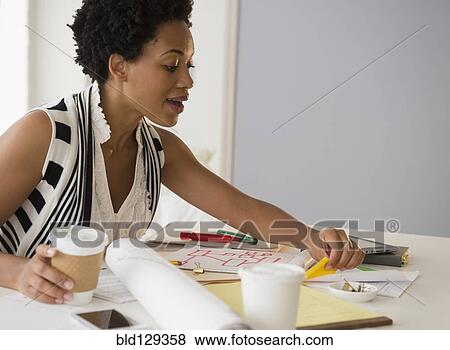 Black businesswoman drinking coffee and working View Large Photo Image Stock Photo - Black businesswoman drinking coffee and working. Fotosearch