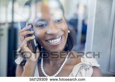Stock Photo - Black businesswoman talking on cell phone on train. Fotosearch