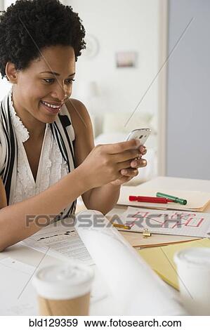 Stock Photo - Black businesswoman using cell phone. Fotosearch