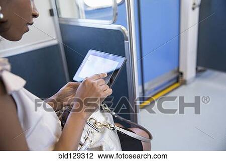Black businesswoman using digital tablet on train View Large Photo Image Stock Image - Black businesswoman using digital tablet on train. Fotosearch