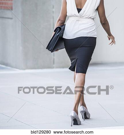 Black businesswoman walking on city street View Large Photo Image Stock Image - Black businesswoman walking on city street. Fotosearch