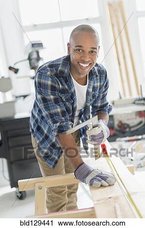 Black carpenter working in shop View Large Photo Image Stock Image - Black carpenter working in shop. Fotosearch