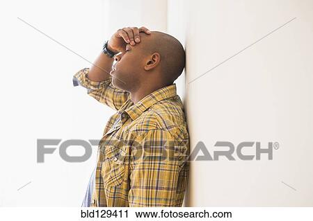Black man rubbing his forehead View Large Photo Image Stock Image - Black man rubbing his forehead. Fotosearch