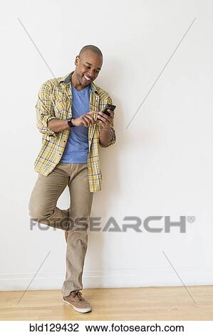 Stock Image - Black man using cell phone. Fotosearch