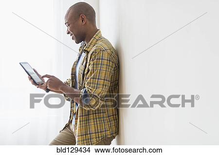 Picture - Black man using digital tablet. Fotosearch