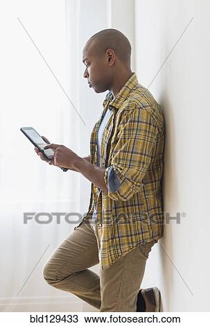 Black man using digital tablet View Large Photo Image Stock Image - Black man using digital tablet. Fotosearch