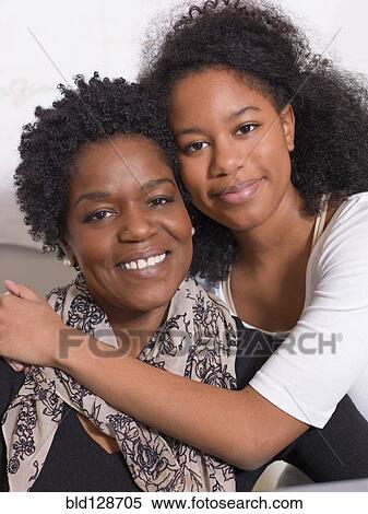 Stock Photography - Black mother and daughter hugging. Fotosearch