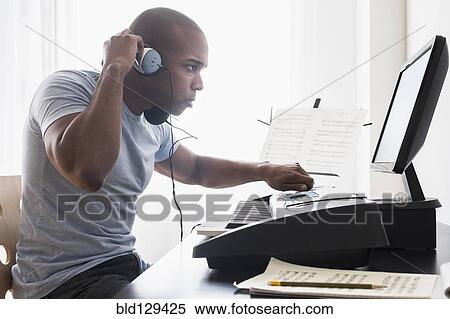 Stock Photography - Black musician writing music with computer. Fotosearch