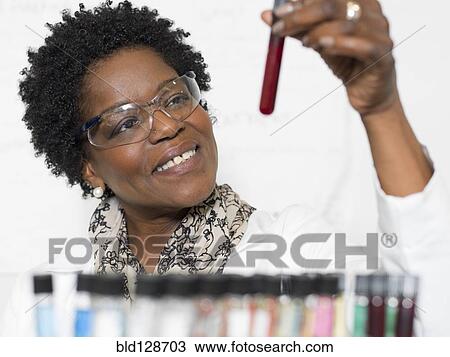 Stock Image - Black scientist examining samples in lab. Fotosearch