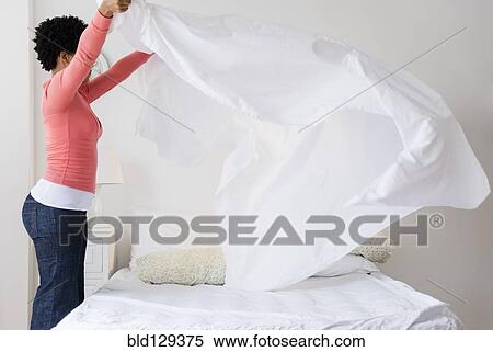 Stock Photography - Black woman making bed. Fotosearch