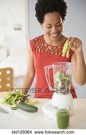 Black woman making green smoothies in blender View Large Photo Image Picture - Black woman making green smoothies in blender. Fotosearch