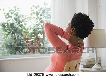 Black woman relaxing at window with hands behind head View Large Photo Image Stock Photograph - Black woman relaxing at window with hands behind head. Fotosearch