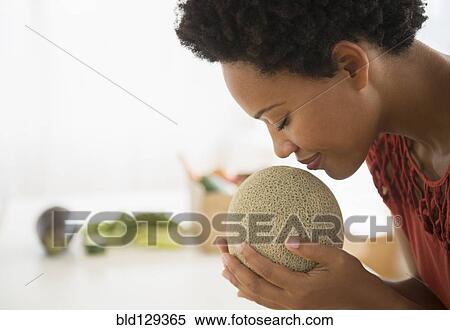 Black woman smelling cantaloupe View Large Photo Image Stock Photography - Black woman smelling cantaloupe. Fotosearch