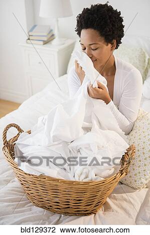 Black woman smelling fresh laundry on bed View Large Photo Image Stock Image - Black woman smelling fresh laundry on bed. Fotosearch
