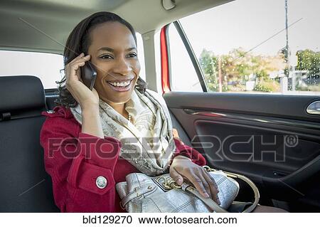 Black woman talking on cell phone in taxi View Large Photo Image Stock Image - Black woman talking on cell phone in taxi. Fotosearch