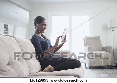 Black woman using digital tablet on sofa View Large Photo Image Stock Image - Black woman using digital tablet on sofa. Fotosearch