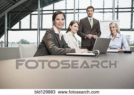 Stock Image - Business people sitting in meeting. Fotosearch