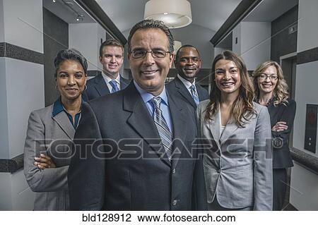 Stock Image - Business people smiling in office corridor. Fotosearch